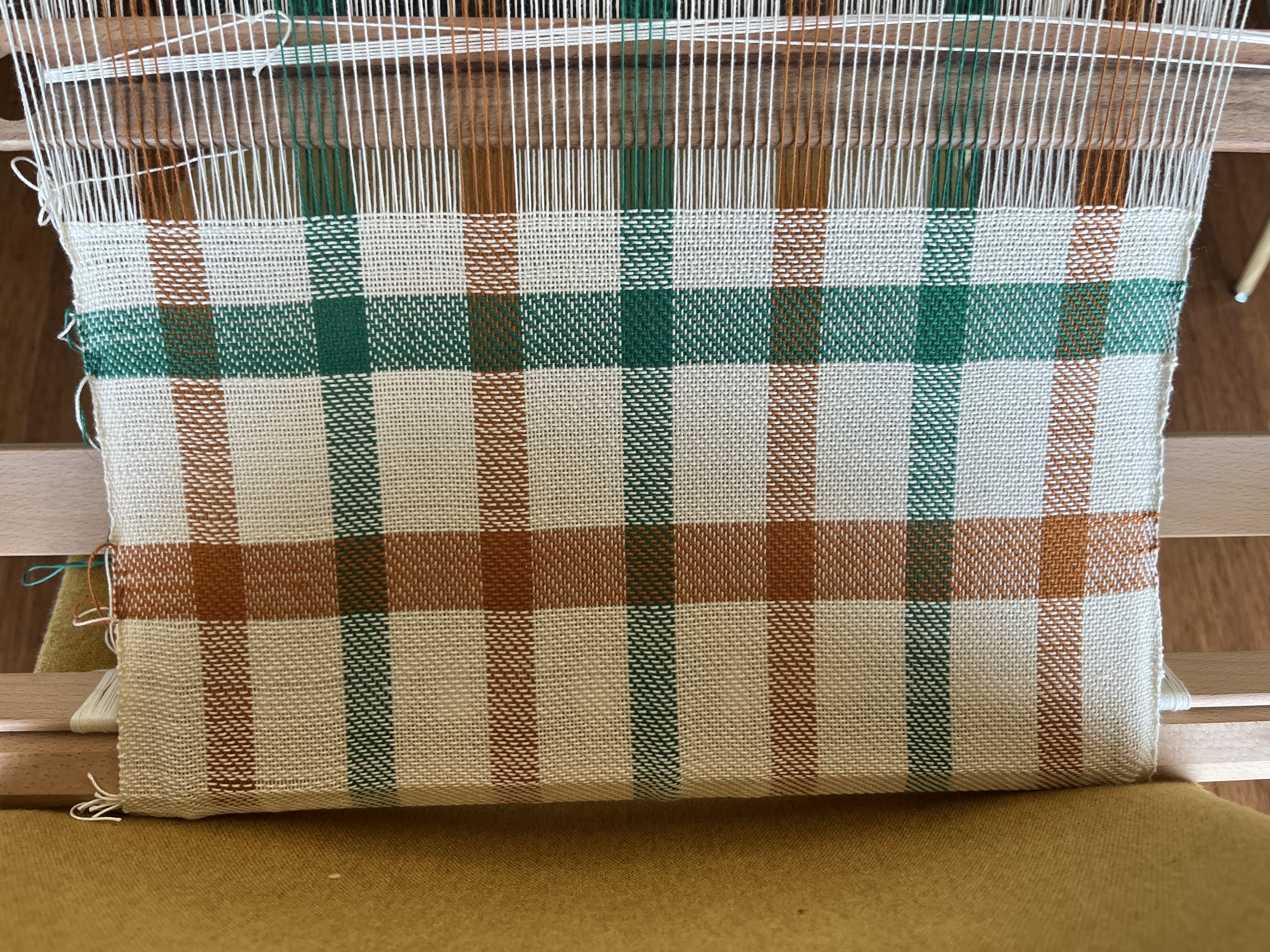 Photo of loom with some weaving on it.